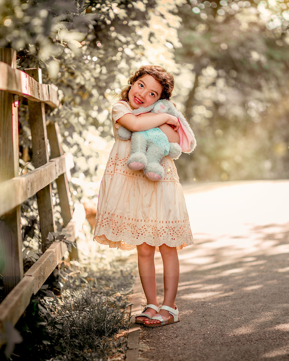 Child in the park cuddling bunny. Lightroom edit.