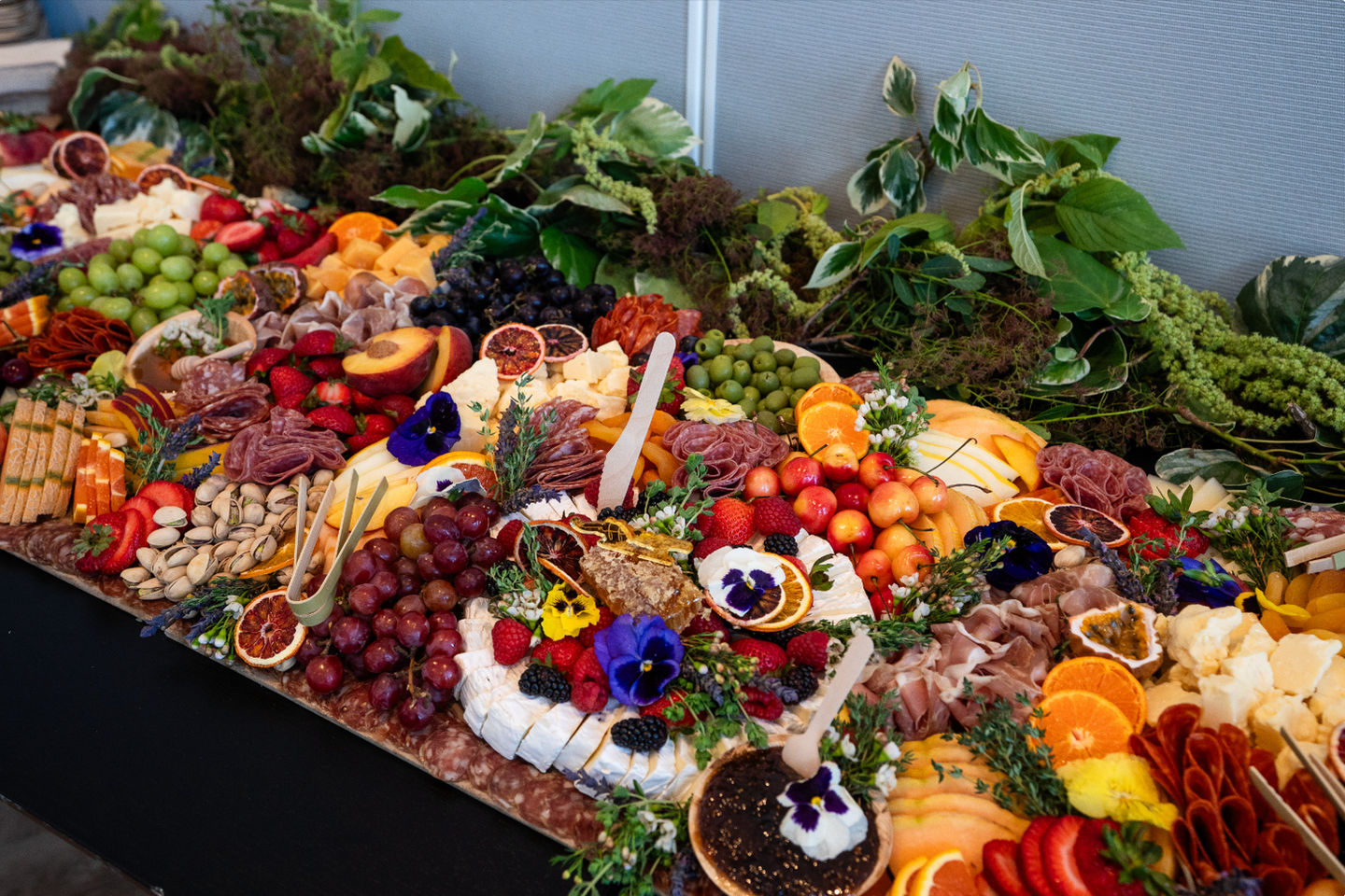 Large, colorful spread of vegetables, meats, fruits, and cheeses at the Artists on Artists Fireside Chat, Cultured Magazine event in San Francisco.