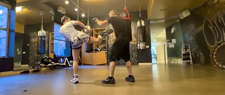 A private client practicing side kicks with Coach Mike.