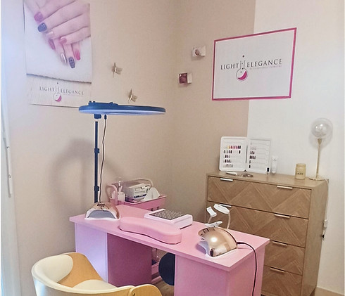 Salon de manucure rose avec des lampes et des affiches décoratives. Elysium Beauty