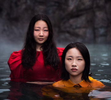 Two women at Sky Lagoon, one red dress, other yellow, fashion editorial 