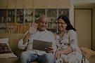 indian-asian-senior-couple-video-chatting-tablet-computer-while-sitting-couch-garden-home-