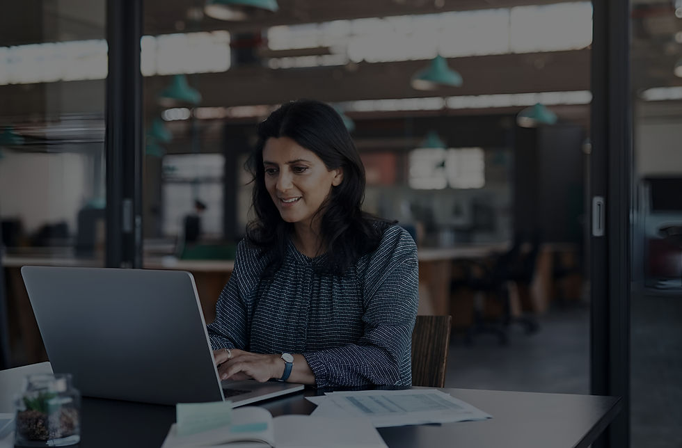 businesswoman-smiling-while-working-laptop-office_edited.jpg