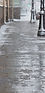 De-icing chemicals on the winter road_ Pavement is sprinkled with technical salt or salt m