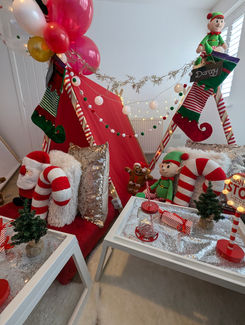 a room decorated for christmas with a sign that says santa stop here