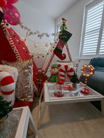 a santa stop here sign is lit up in a living room