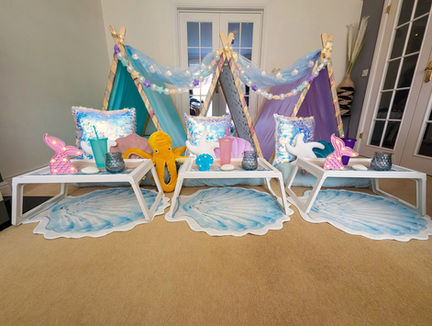 Colourful indoor tents with shell pillows and decorative mermaid items.