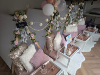 Cosy seating with pillows and decorative floral arrangements.