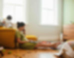 Working mother on laptop with child climbing on a chair
