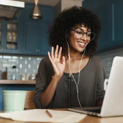 Woman waving during an online nutrition consultation