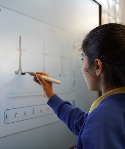 A child wrtiing on a whiteboard