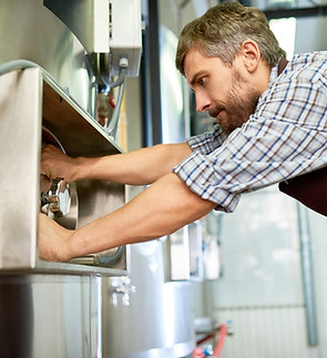 66166d071cce6e53833e6ee3_2021_08_busy-skilled-maintenance-technician-repairing-brewery-equ