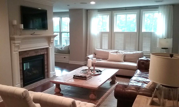 Completed interior painting project in Saratoga Springs NY showing professionally painted living room with fireplace crown molding and neutral wall colors