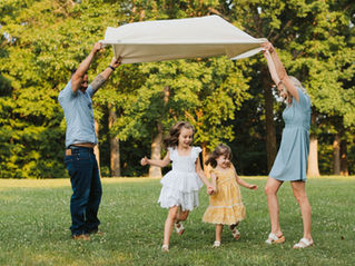 a family plays together in South Park during their lifestyle family photography session