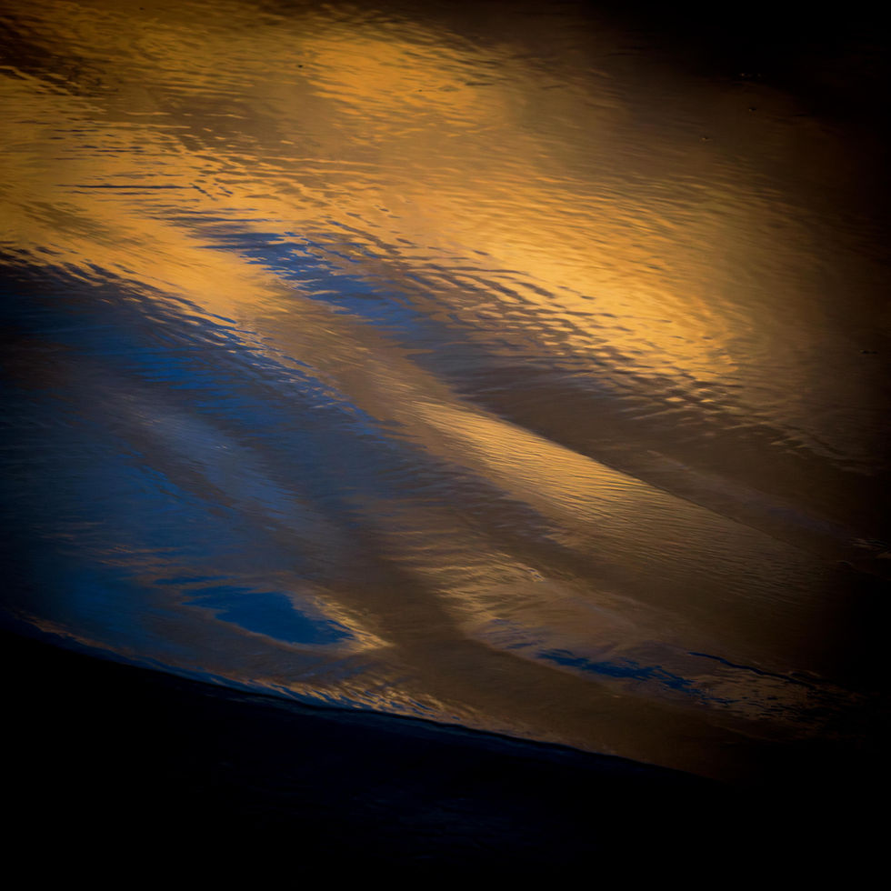 A colourful sunset tinted sky reflected in the wet sand of the beach at Waxham Sands, Norfolk.