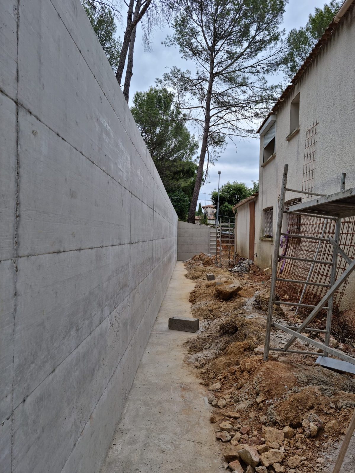 Mur de soutènement en béton terminé, avec drainage au pied