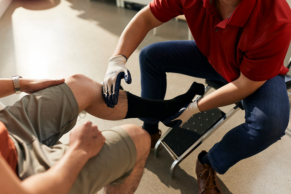 A Paris everyBODY certified fitter wearing gloves is helping a client put compression socks on for the first time.