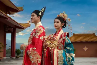 The couple pose in traditional attire on temple steps for their pre wedding photoshoot.