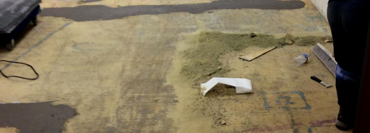 Long commercial corridor showing a completed installation of durable grey carpeting.