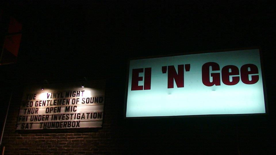 A sign of the El 'N' Gee in New London, Connecticut with the band Under Investigation on it. An image of the Hemlock Mouth Collective Show No Silence, No Permission at 33 Golden St. in New London, Connecticut and an image of the zine Unwritten, Unbroken: We Speak in Thunder Now. The submission poster for the Hemlock Mouth Collective.