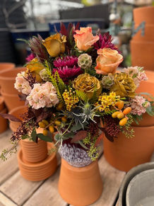 Earth-toned floral arrangement in a terracotta pot