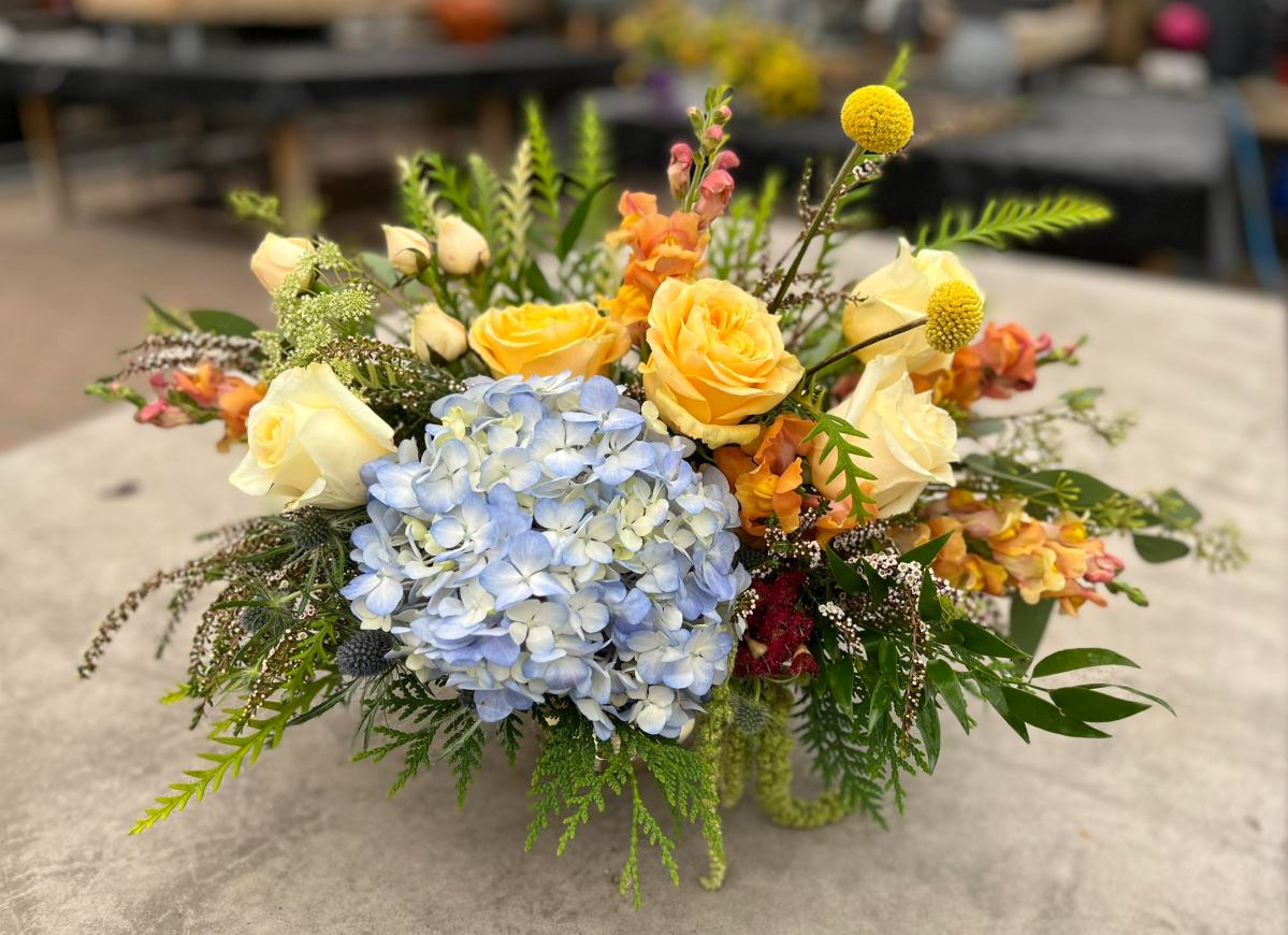 Blue hydrangea and yellow rose floral arrangement