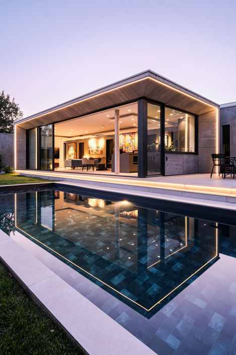 vue extérieure d'une maison contemporaine de luxe avec façade vitrée, jardin paysager et piscine, conçue par un architecte à Lyon - projet haut de gamme en Rhône-Alpes