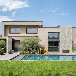Villa contemporaine de luxe avec façade en enduit et pierre naturelle, grandes baies vitrées et piscine moderne, conçue par un architecte à Lyon, France