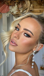 Blonde artist with elegant updo and pearl earrings.