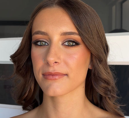 Amy with professional makeup and styled wavy hair.