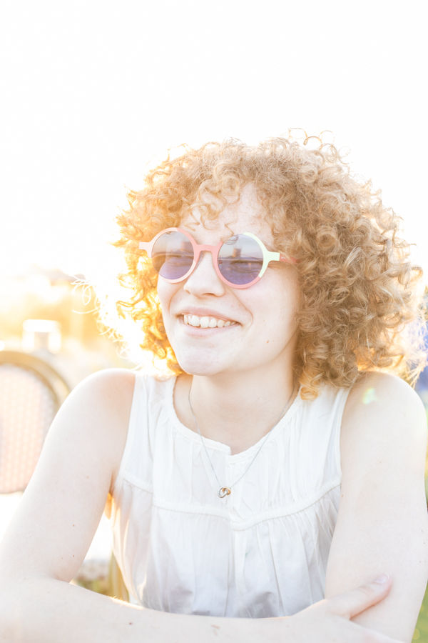 Titanium frame fashion sunglasses with irregular round frame and blue polarised lens on model