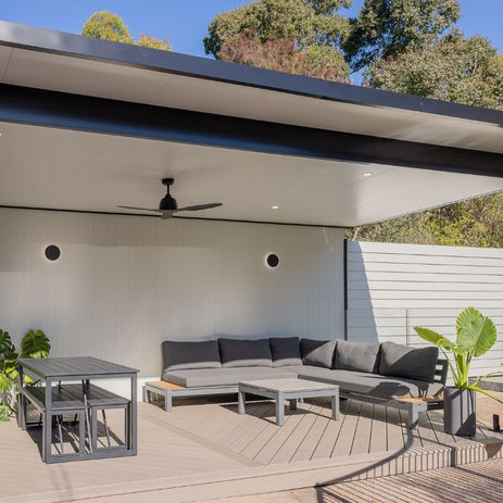Contemporary pool cabana featuring Spotted Gum hardwood, James Hardie V-groove cladding, Trex Biscayne decking laid diagonally, and a Versiclad insulated pergola on aluminium beams. Includes a custom BBQ area with polished concrete bench and bar fridge.