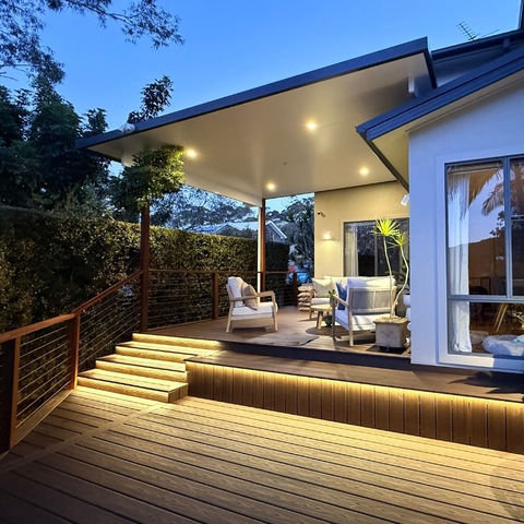 Trex Spiced Rum composite deck with insulated pergola, aluminium beams, Merbau posts and handrail, stainless wire balustrade, built-in lighting, bench seating and stairs — Woronora.