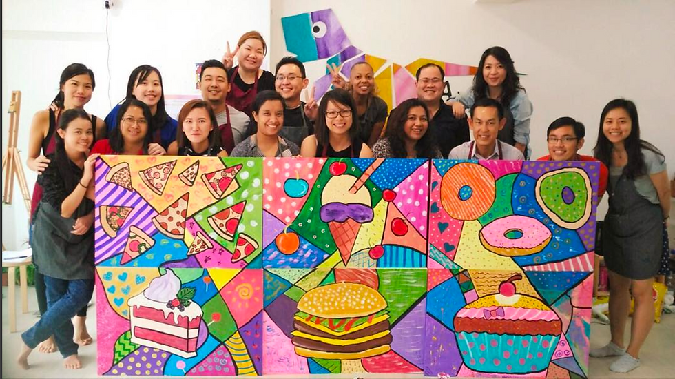 A smiling group, holding up their completed painting, it is brightly coloured. Cheerful and bright, team bonding activity.