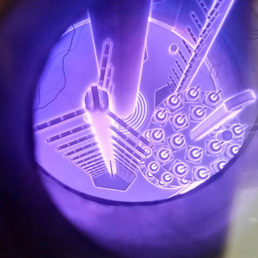 Interior de una cámara de nitruración por plasma que muestra componentes industriales envueltos en un aura de luz ionizada morada.
