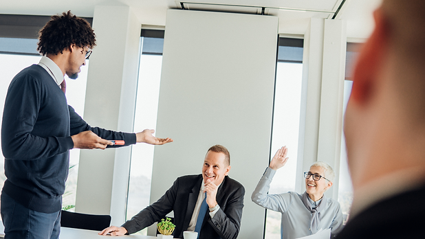 Presenter Calling on Smiling Colleague at Meeting