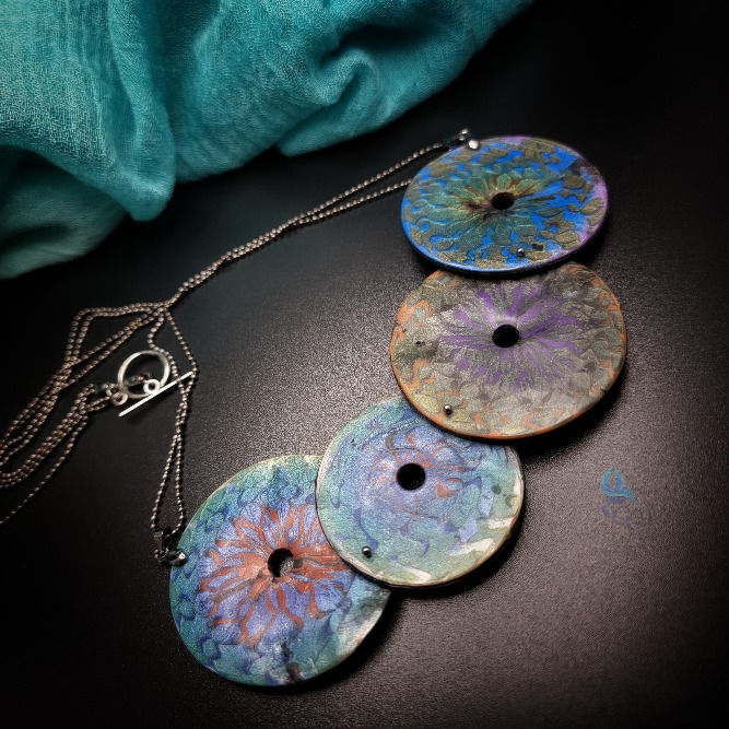 Thumbnail: Necklace with moving elements. The necklace is made of metallic color polymer clay, the elements are moving around a connecti