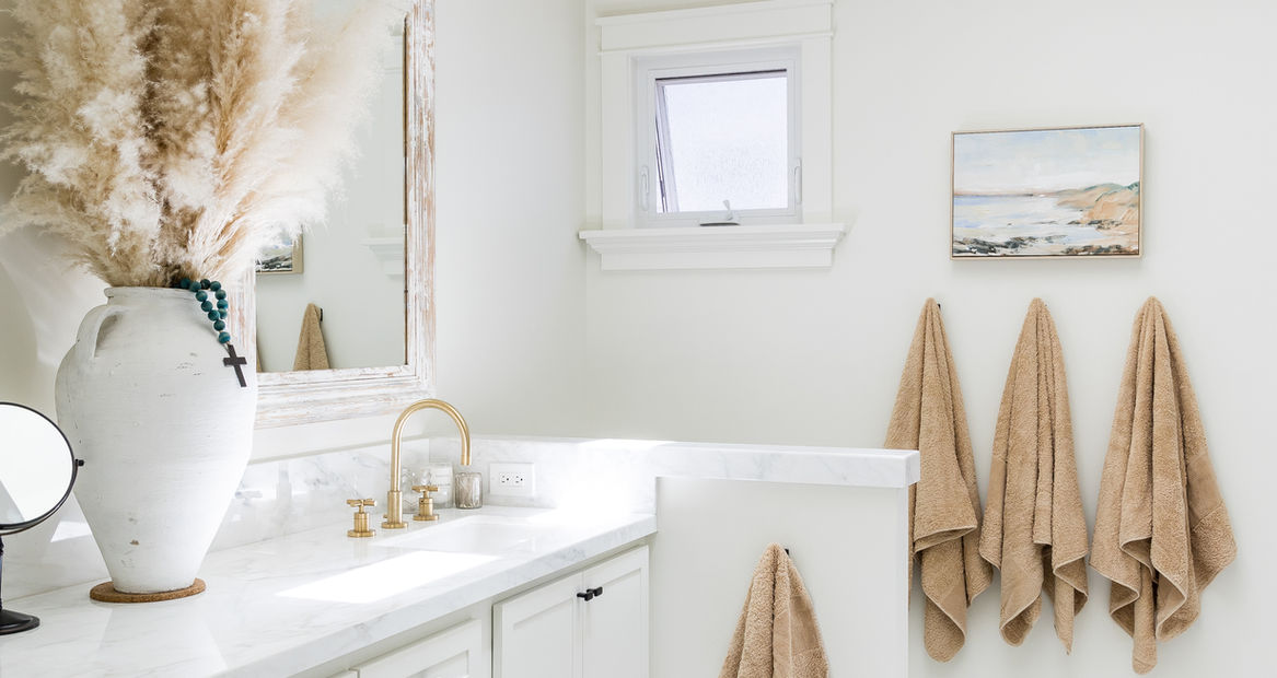 a master bathroom with marble countertops and a large vase
