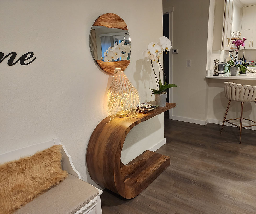 Elegant curved entryway table with decorative accents and orchid, creating a warm and welcoming entrance.