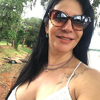 Mãe sorrindo usando óculos de sol em momento ao ar livre