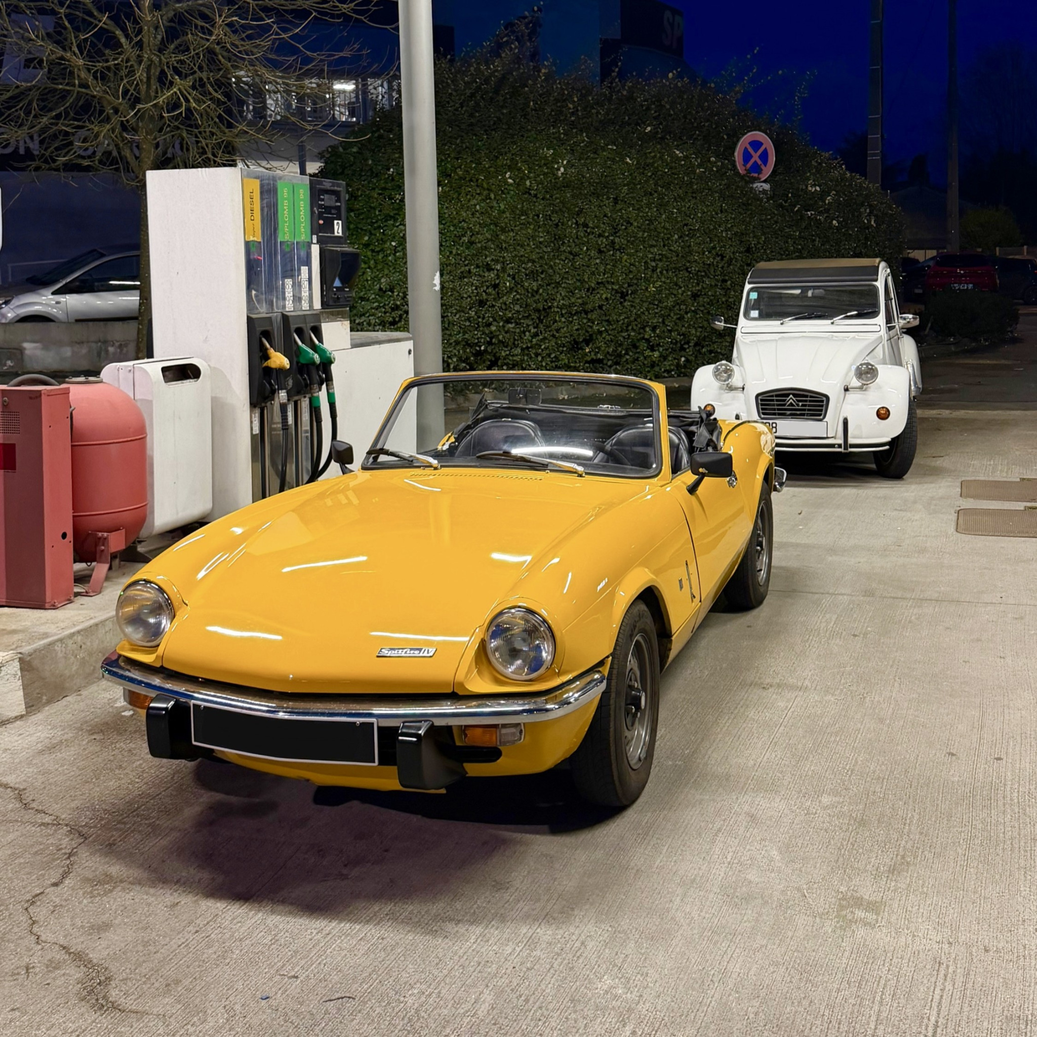 Triumph Spitfire jaune et Citroën 2CV blanche de nuit