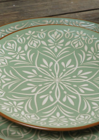 Soft green stoneware dinner range with a terracotta rim and an arabic inspired embossed printed pattern.