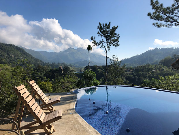 a pool and sun bathing chairs overlooking the jungles in Semuc Champey, Guatemala at Vista Verde Hostel