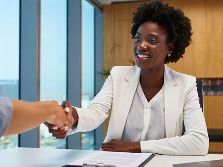 Black woman with afro shaking a white person's hand