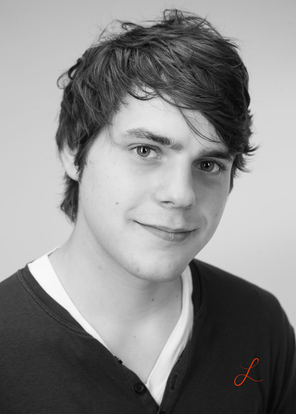 Portrait eines jungen Mannes in Schwarzweiß. Er lächelt. 
