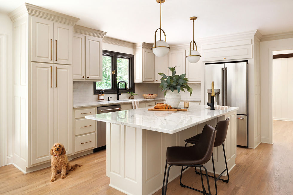 Light cream kitchen with marble island, brass pendants and black fixtures; friendly dog by the pantry — The Peachy Home Co.