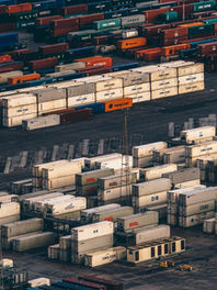 Stacks of shipping containers at a busy cargo port