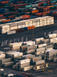 Stacks of shipping containers at a busy cargo port