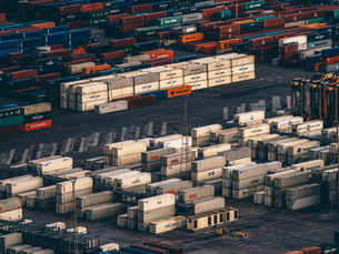 Stacks of shipping containers at a busy cargo port