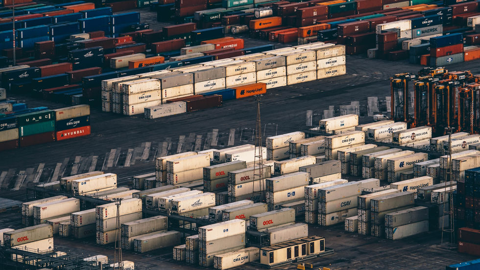 Stacks of shipping containers at a busy cargo port